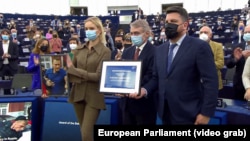 Darya Navalnaya (left) accepted the award in Strasbourg on December 15 while holding a portrait of her imprisoned father.