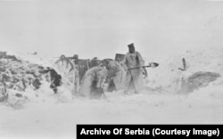 Unidentified soldiers clearing snow from a position during a winter storm.