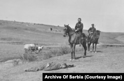 Bulgarian officers looking at the body of an Ottoman soldier.