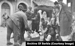 Montenegrin soldiers haggling with a tobacco seller in an unidentified town.