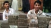 Two money-changers wait for customers at an exchange market in Kabul.