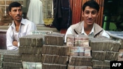 Two money-changers wait for customers at an exchange market in Kabul.