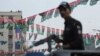 An armed policeman stands guard during an election campaign event in the southern seaport city of Karachi.