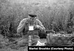 A man with a disability takes a break from helping his neighbors dig potatoes, Khoynitsky district, Homel Oblast, 1996.