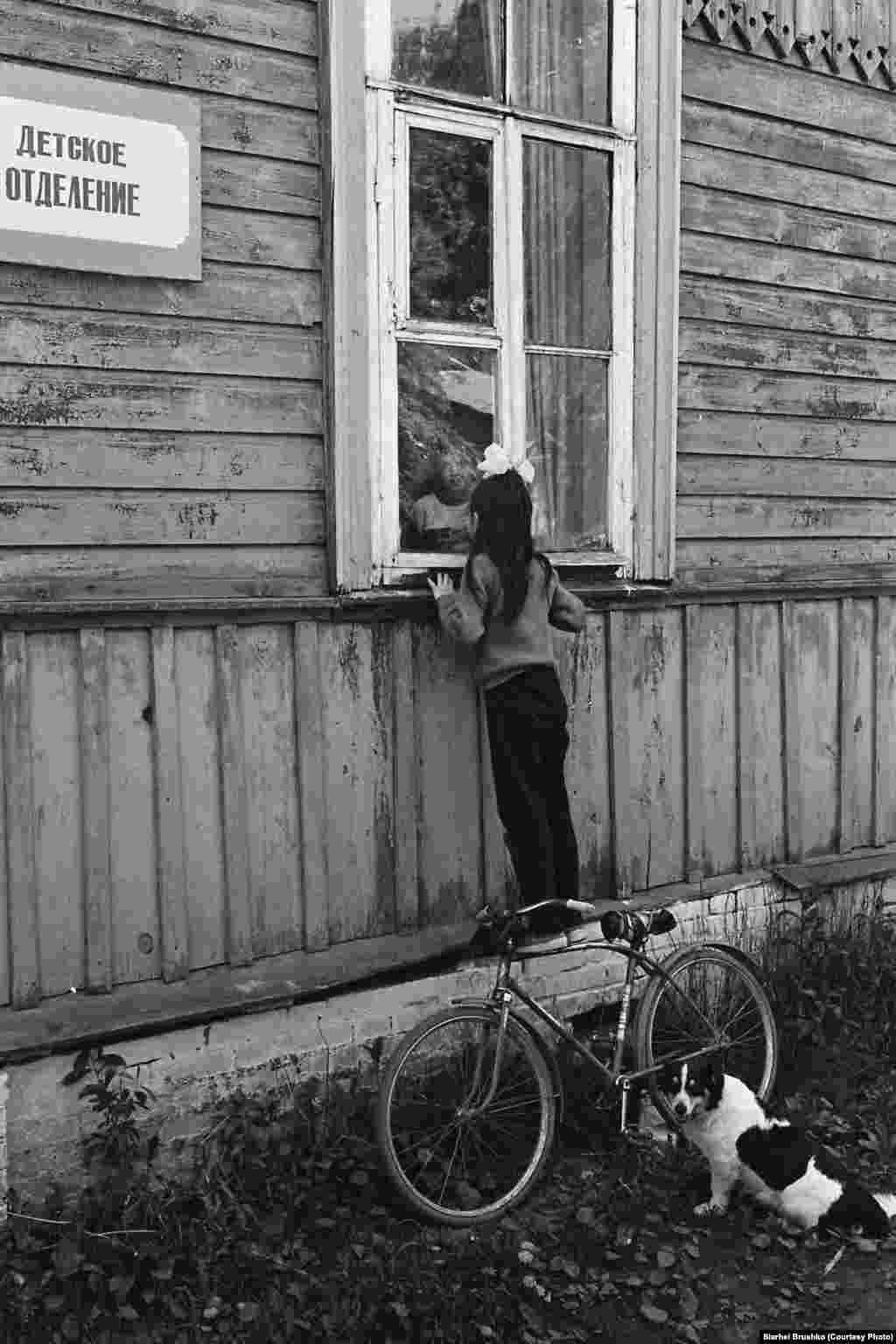 A girl looks into the window of a children&#39;s hospital, 1988.