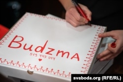 A waitress writes on a takeaway box.