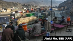 Drivers rest as stranded trucks are pictured near the Pakistan-Afghanistan border at Torkham on January 16. 