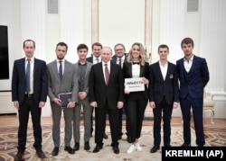 Russian President Vladimir Putin (center) poses with winners of the 2019 Business Prize for small and medium-sized enterprises, including Ilya Sachkov (second from left), at the Kremlin on February 6, 2019.