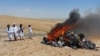 Members of the Taliban morality police stand beside a bonfire of musical instruments and equipment they confiscated and burned in the Western Afghan city of Herat on July 29.