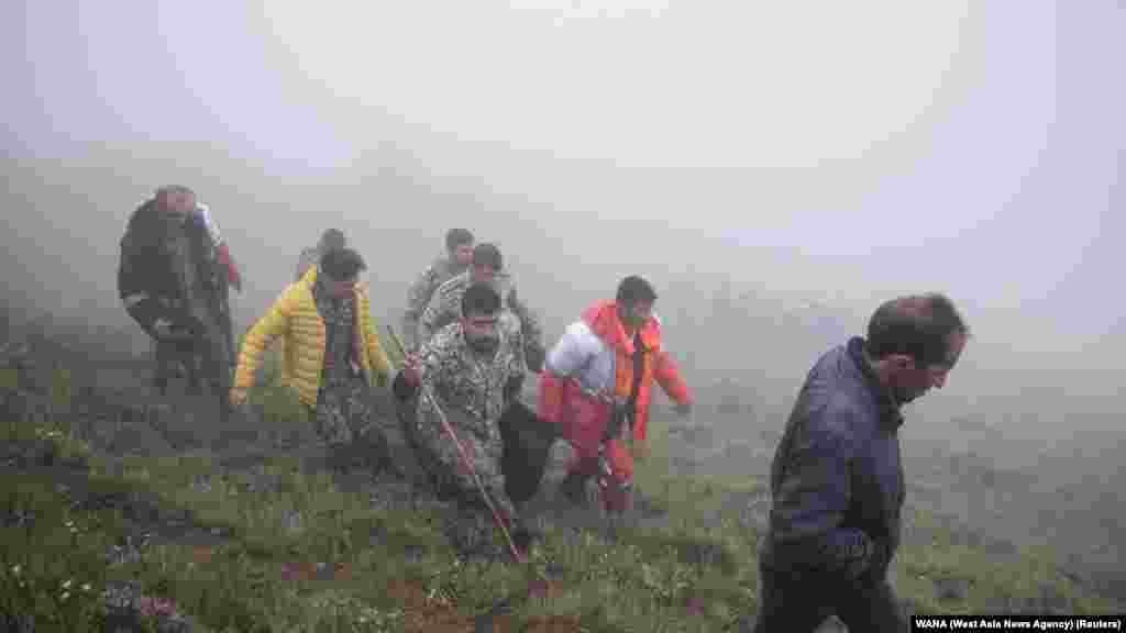 Rescuers recover bodies at the site where a helicopter carrying Iranian President Ebrahim Raisi crashed in a fog-shrouded mountainous area of northwest Iran on May 20. Raisi, 63, and his companions, including Foreign Minister Hossein Amir-Abdollahian, have been found dead at the site of the crash.&nbsp;&nbsp;