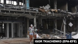 A couple walks past debris in the aftermath of a drone attack close to the border with Romania in the Ukrainian city of Izmayil in August.