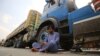 A driver sits beside his parked truck, carrying goods destined for Afghanistan, waiting for the opening of the border following clashes between the security forces of Pakistan and Afghanistan, in Torkham, Pakistan, on September 7.