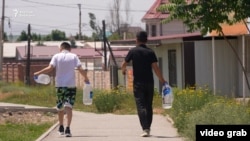 Two boys take bottles to fill with drinking water in Bishkek, where modest rations of water are distributed from a tanker once a day.