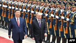 Russian President Vladimir Putin and Chinese leader Xi Jinping review a military honor guard during an official welcoming ceremony in Beijing on May 16.