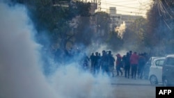 Supporters of Imran Khan's Pakistan Tehreek-e-Insaf (PTI) party run from tear gas while they protest against the alleged rigging of Pakistan's national election results, in Rawalpindi on February 11.