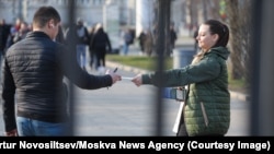 A man in Russia receives a leaflet urging people to join the military.