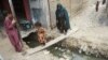 An Afghan girl and her mother cross an open sewer at a refugee camp in Karachi. Pakistan has said that it plans to deport over 1 million Afghans living in the country who do not have valid residency documents. 