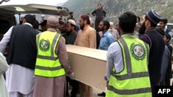 Volunteers transport the coffins of a Chinese national from a hospital following a suicide attack the Shangla district of Khyber Pakhtunkhwa Province on March 26.