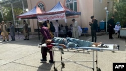 An injured Afghan man is brought to a hospital following an earthquake in Herat on October 15.