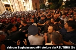 Protesters confront police standing guard outside the government building in Yerevan on September 21 during a rally to demand the resignation of Prime Minister Nikol Pashinian following Nagorno-Karabakh's surrender.