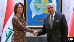 Iraqi Foreign Minister Fuad Hussein (right) receives his German counterpart, Annalena Baerbock, at the Foreign Ministry in Baghdad on March 7.