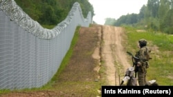 A Latvian Border Guard officer patrols along the fence at the Latvian-Belarus border near Robeznieki in August.