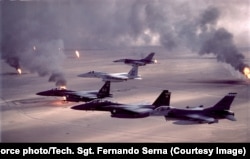 F-16 and F-15 jets (distinctive for their twin tails) fly over burning oil fields in Iraq in 1991 during the Gulf War.