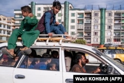 Afghan boys travel in a Toyota Corolla taxi in Kabul. (file photo)