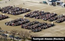 Japanese protesters form the message "NO WAR NO DU" during a rally opposing the 2003 invasion of Iraq and the use of depleted uranium.