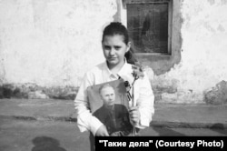 A young girl holds an "Immortal Regiment" photo. On May 9, Russians march with photographs of relatives who gave their lives or otherwise contributed to the Soviet war effort in World War II.