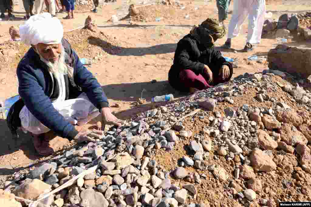 Mourners sit beside graves after funeral prayers for their relatives. In addition to the WFP, teams from the UN&#39;s World Health Organization (WHO) have rushed to the areas of Herat worst affected by the quakes. WHO employees are already in the field helping with efforts to rescue and treat people still under the rubble, the organization&#39;s Afghan branch told RFE/RL.