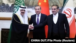 Chinese Foreign Minister Wang Yi (center) poses with Ali Shamkhani, secretary of Iran's Supreme National Security Council (right) and Saudi Arabia's national security adviser, Musaad bin Muhammad al-Aiban (left), in Beijing on March 10.