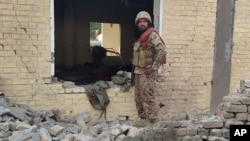 An Pakistani soldier examines the damage at the site of a bombing of a police station on the outskirts of Dera Ismail Khan on December 12.