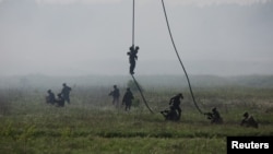 Polish soldiers from 25th Air Cavalry Brigade land during the Defender Europe 2022 military exercise of NATO troops at the military range in Bemowo Piskie, near Orzysz, Poland, on May 24, 2022.