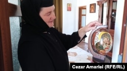 Mother Abbess Paisia shows an ostrich egg painted at the monastery near Ceatalchioi.