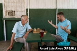 Roman Padolkin and Yuriy Obukhov play chess at a bar in Nikopol.