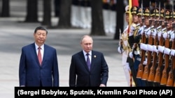 Chinese President Xi Jinpin (left) and Russian President Vladimir Putin review an honor guard during an official welcome ceremony in Beijing on May 16.