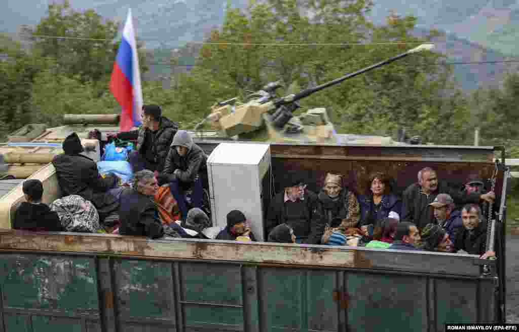 Armenian refugees sit in the back of a truck at the Lachin checkpoint, controlled by Russian peacekeepers and Azerbaijani border guards, as they wait to cross into Armenia. Baku has pledged equal treatment for ethnic Armenians, but Yerevan has warned of possible &quot;ethnic cleansing.&quot; &nbsp;