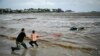 People try to pull out a car submerged in the sea at a camping site near Tsarevo on the Bulgarian Black Sea coast on September 6. 