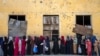 Afghan women wait to receive food rations distributed by a humanitarian aid group in Kabul on May 28.