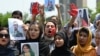 Afghan nationals carry placards as they shout slogans during a demonstration against the Taliban-led government in Islamabad on August 15.