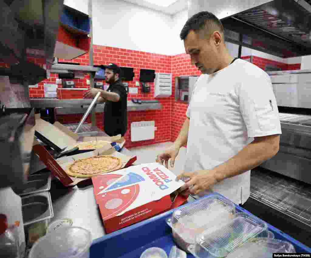 A worker boxes pies in a rebranded Domino&#39;s Pizza outlet in Moscow on August 30.&nbsp; In late August, Domino&#39;s became the latest major Western brand to exit the Russian market after failing to sell the business. Domino&#39;s was the third-largest pizza-delivery chain in the country, with 142 stores. &nbsp;