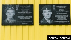 Memorial plaques on the school in the village of Kuratovo, where Semyon (left) and Aleksandr Tutrinov studied.