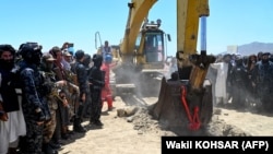 Taliban security personnel surround an excavator at work during an inauguration ceremony of the Mes Aynak copper-mining project on July 24.