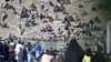 Afghan refugees sit on a hilltop outside the International Organization for Migration office as they wait for registration upon their arrival from Pakistan near the border in Nangarhar Province on November 12.