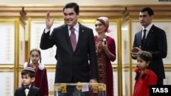 Turkmen President Gurbanguly Berdymukhammedov (center) casts his ballot as his son Serdar (right) watches with other family members at a polling station in Ashgabat in February 2017.