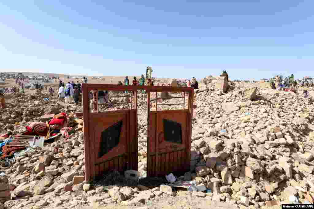 Afghan residents clear debris as they continue their search for bodies in the rubble of homes destroyed during the earthquakes. &nbsp;