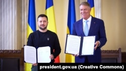 Ukrainian President Volodymyr Zelenskiy (left) with his Romanian counterpart, Klaus Iohannis, after they signed a joint declaration in Bucharest on October 10.