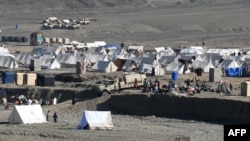 Afghan refugees sit outside their tents at a makeshift camp upon their arrival from Pakistan near the Afghanistan-Pakistan Torkham border in Nangarhar Province on November 12.