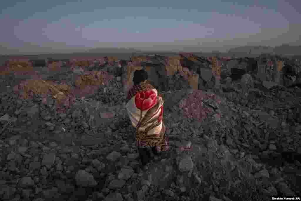 An Afghan man searches for victims in the dusk. Disaster authority spokesperson Mohammad Abdullah Jan said four villages in the Zindah Jan district in Herat Province bore the brunt of the quake and aftershocks.